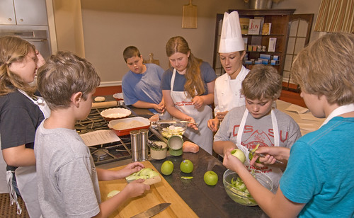 Kids participating in a cooking class hosted by a professional chef.