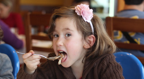 A young girl enjoying a meal at a local family-friendly restaurant.
