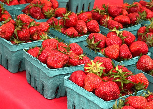 Pint baskets of freshly picked strawberries at a farmer's market.