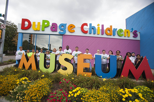 Part of the staff gathering around the sign at the DuPage Children's Museum.