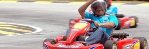 A young boy having fun driving a go kart around a go cart track.
