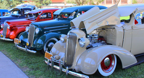 Vintage cars lined up and on display during a local car show.