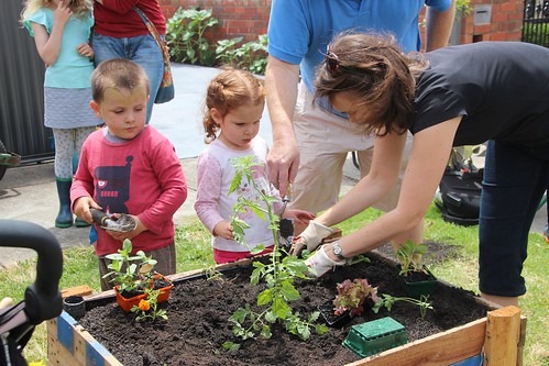 Teaching young children important lessons in planting with a raised planter box.