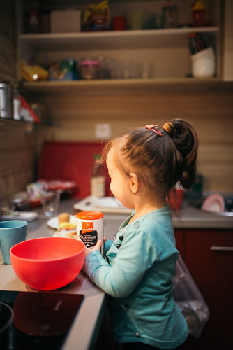 A young girl helping to make food in her family kitchen.