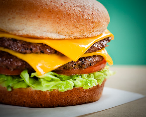 A picture-perfect double cheeseburger with lettuce and tomato.