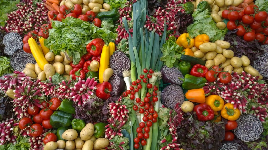 A wide variety of fresh vegetables spread out across a table.