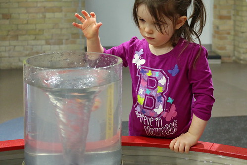 A girl experiencing a water vortex at an interactive local children's museum.
