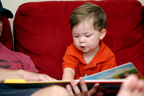 An infant being read to by his father