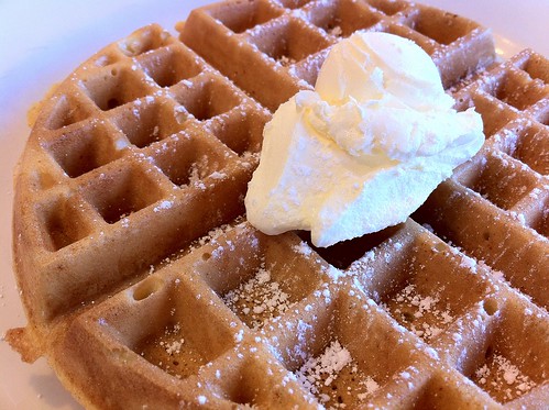 A crisp, fluffy waffle topped with whipped butter.
