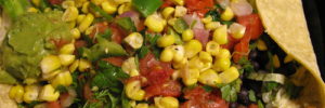 A delicious all-vegan taco salad with corn, guacamole, and corn tortillas.