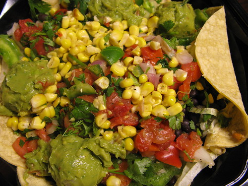 A delicious all-vegan taco salad with corn, guacamole, and corn tortillas.