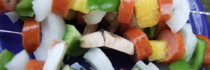 Onion, bell pepper, mushroom, pineapple, and sausage kabobs ready to go over the fire.