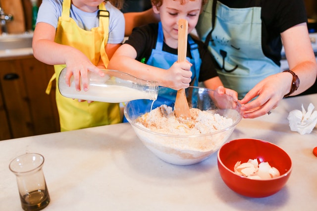 Children mix dough together during a kids' cooking class in Ellisville, MO