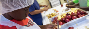 A boy peels in apple during a cooking class