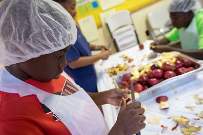 A boy peels in apple during a cooking class