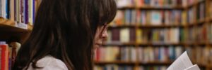 A woman sits on the floor reading a book at the public library in Goodyear, AZ