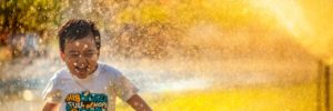 A child runs through a splash of water at the splash pad in Peoria, AZ