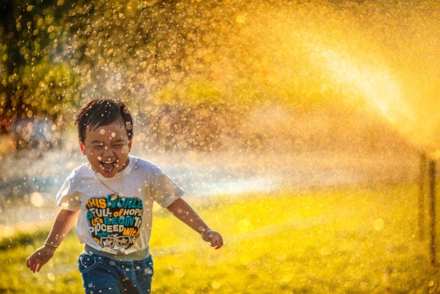 A child runs through a splash of water at the splash pad in Peoria, AZ