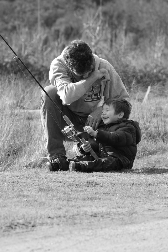 A father and son laughing together while fishing at Thornton Lakes