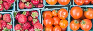 Strawberries and tomatoes in baskets at a farmers market in Romeoville, IL