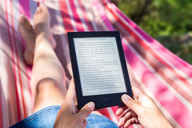 A person reading from an ereader outdoors