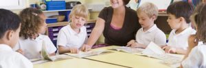 A teacher sits around a table with her students
