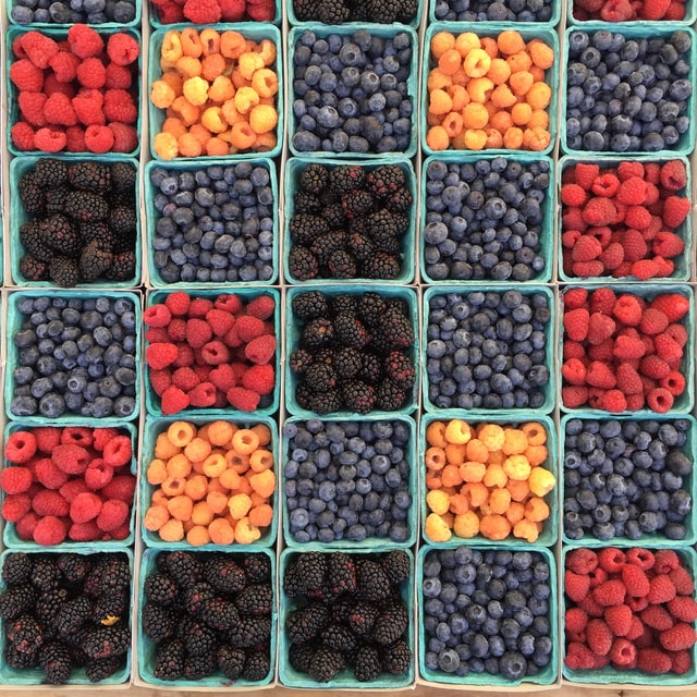 Blueberries, blackberries & raspberries in buckets at the farmers market in McKinney, TX