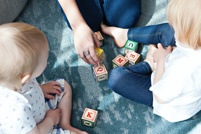 Two young children playing with letter blocks during a language class near Glenview, IL