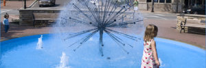 A young girl near a fountain during a day trip to Naperville, IL