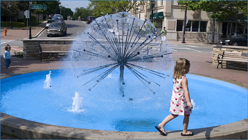 A young girl near a fountain during a day trip to Naperville, IL