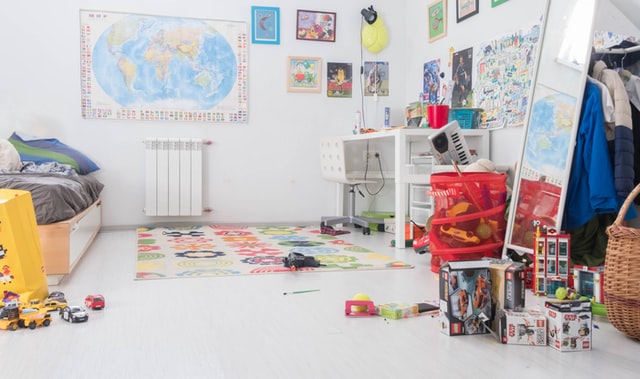 A child's bedroom has toys laying around and needs organization