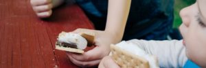 A brother and sister enjoy s'mores while camping near Leawood, Kansas