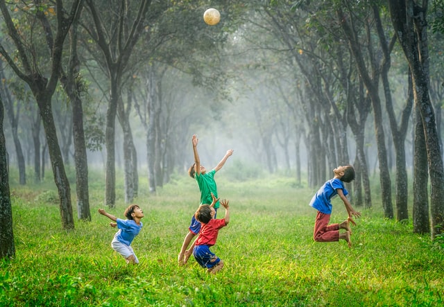 Four kids play with a ball in a field in Frisco, TX