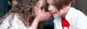 Two children whisper with each other at a language class in McKinney, Texas