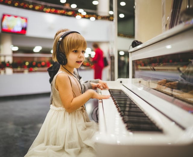 A young girl plays piano at a music class in Las Vegas, NV