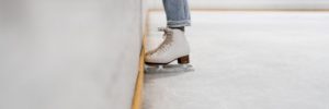 A skater stands near the wall at an ice rink in Glenview, IL
