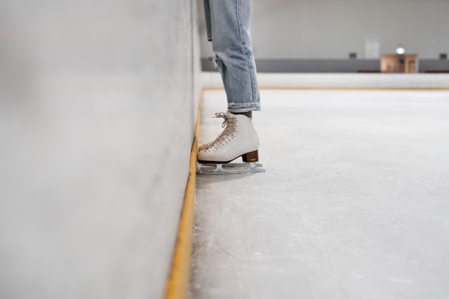 A skater stands near the wall at an ice rink in Glenview, IL