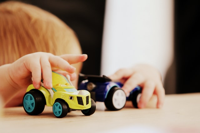 A child plays with two toy cars at the Texas Toy Museum near Cedar Park, TX