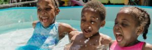 Three kids swimming in a pool at their home in Alpharetta, Georgia