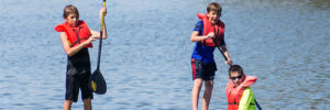 Kids stand on paddle boards on a lake near Coppell, Texas