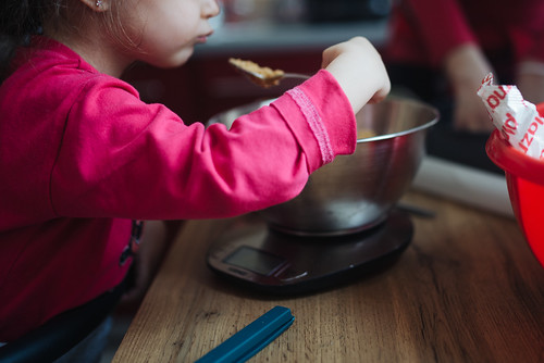 Young Girl Eating Ingredients From A Mixing Bowl
