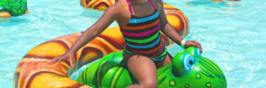 A young girl uses a frog shaped floaty at the aquatic center in Gilbert, Arizona
