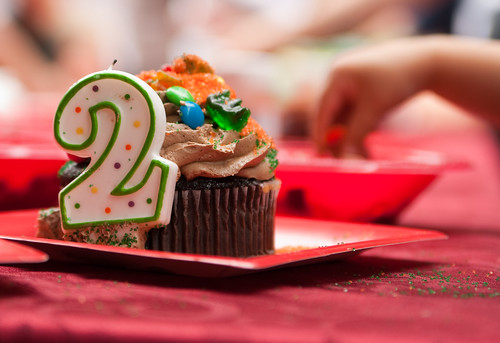 A candle in the shape of a 2 sits near a cupcake at a party venue in Carmel, Indiana