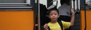 A boy runs off the bus to his first day of school after moving to Thornton, Colorado