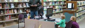 Parents supervise their children as they play on the computer at the public library in Cedar Park, Texas