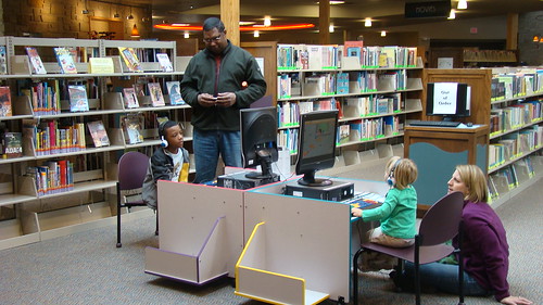Parents supervise their children as they play on the computer at the public library in Cedar Park, Texas