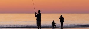 A father and his two sons fish at a waterway in Gilbert, Arizona