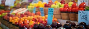 Fruits and vegetables line tables at a farmers market in Thornton, Colorado