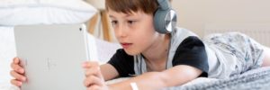A young boy uses social media on his tablet