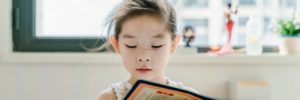 A young girl reads a book at a language class in Peachtree Corners, Georgia